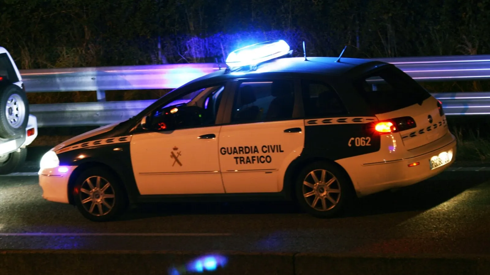 Coche de la Guardia Civil de Tráfico con las luces encendidas de noche